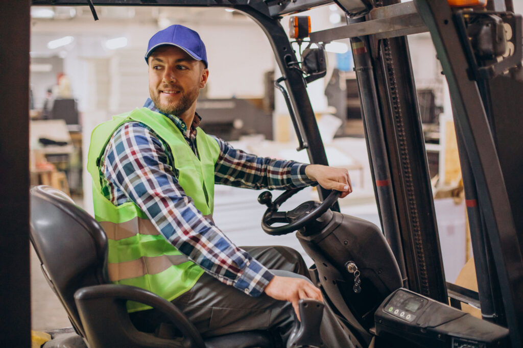 man working at warehouse and driving forklift