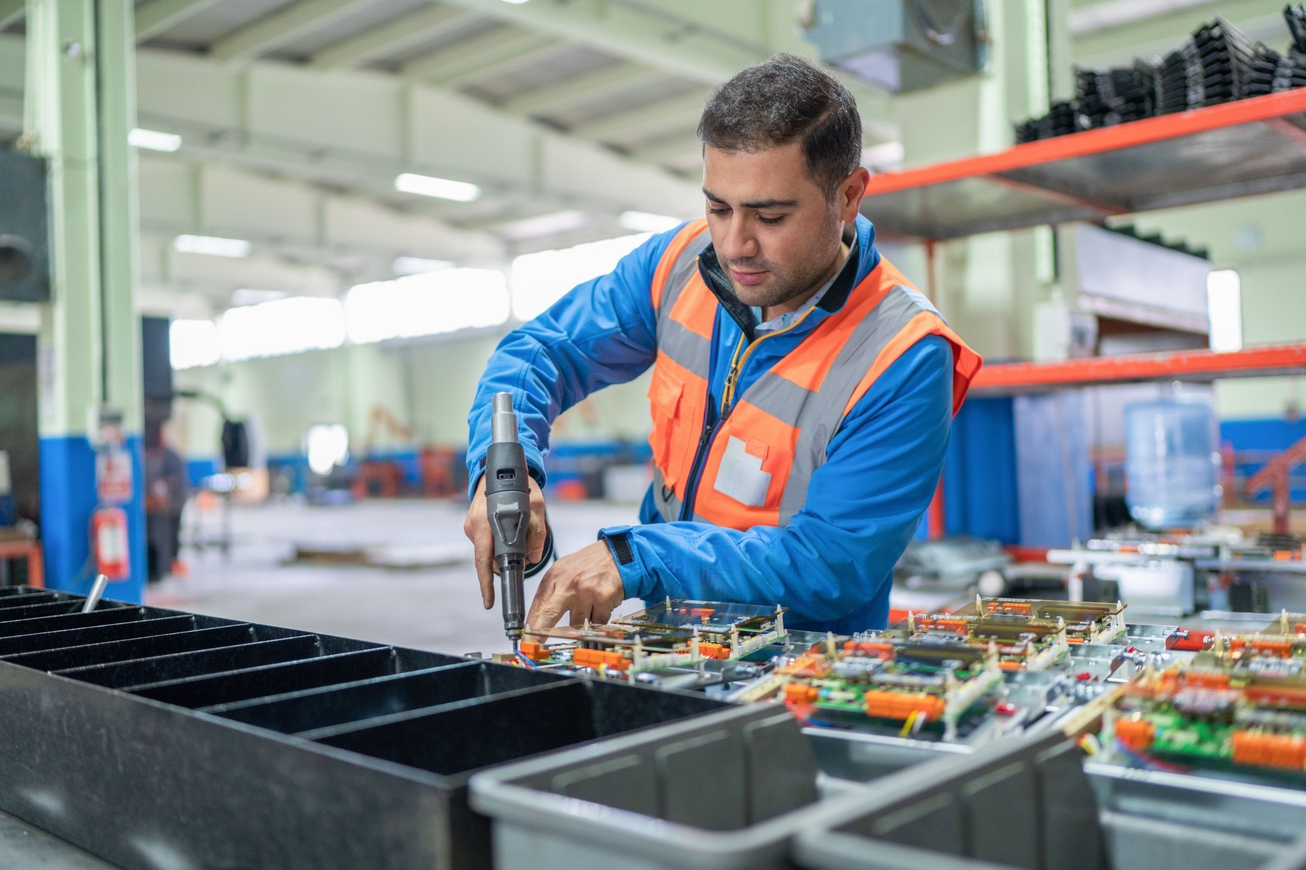 Opérateur assemblant des connecteurs électroniques sur une ligne de production chez Positronic à Auch.