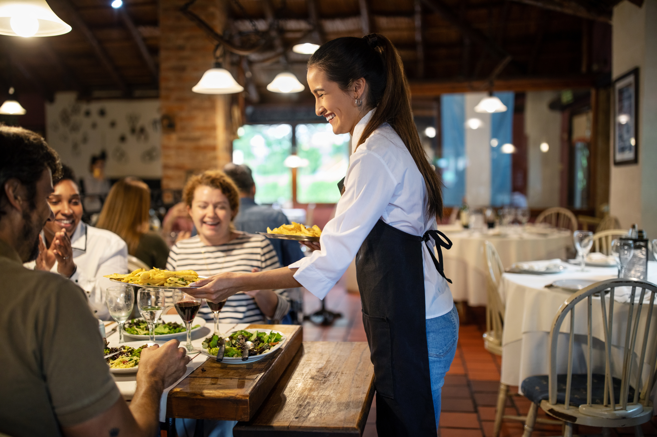 Serveuse apportant des plats à des clients dans un restaurant