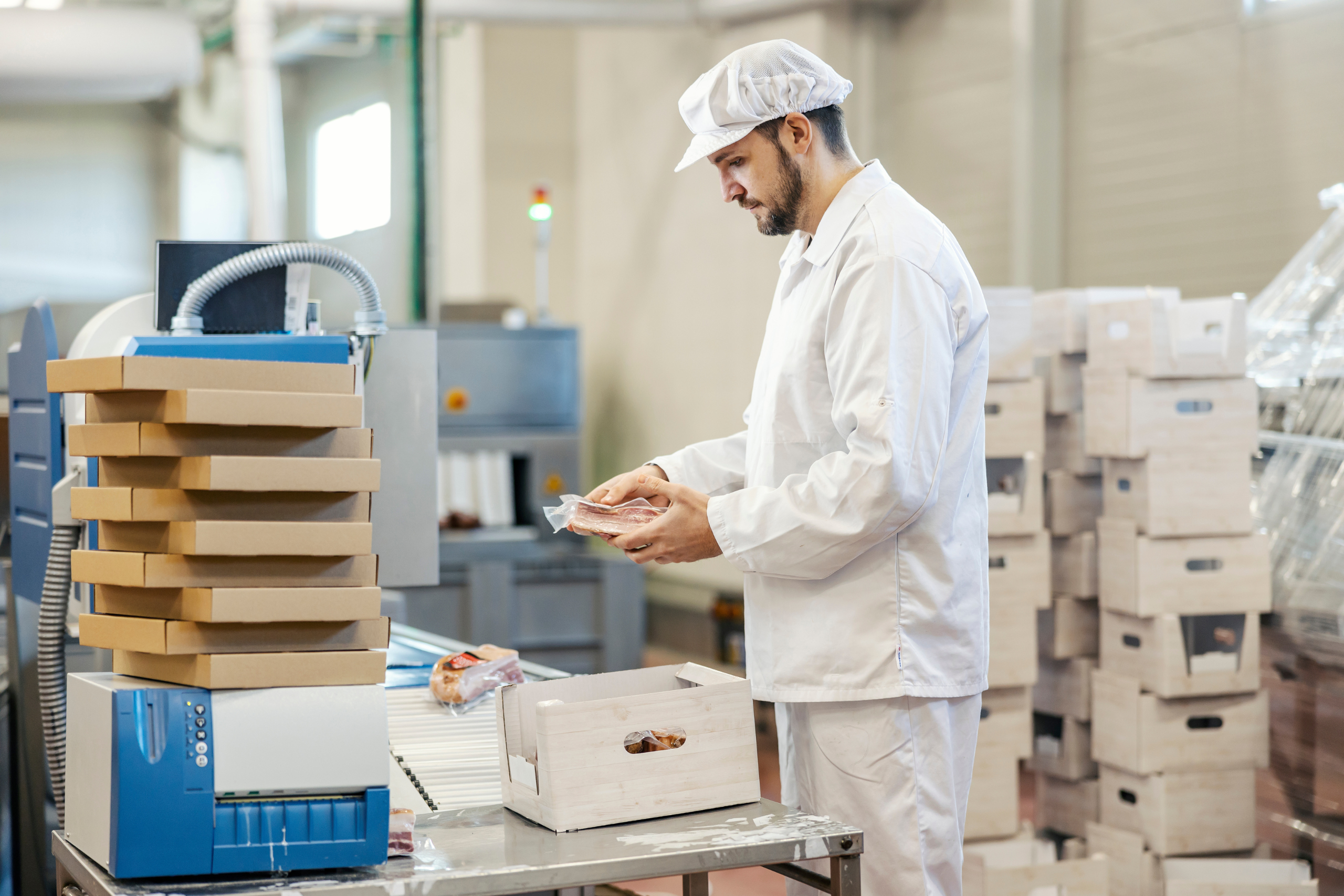 Opérateur agroalimentaire conditionnant un produit dans un atelier de production