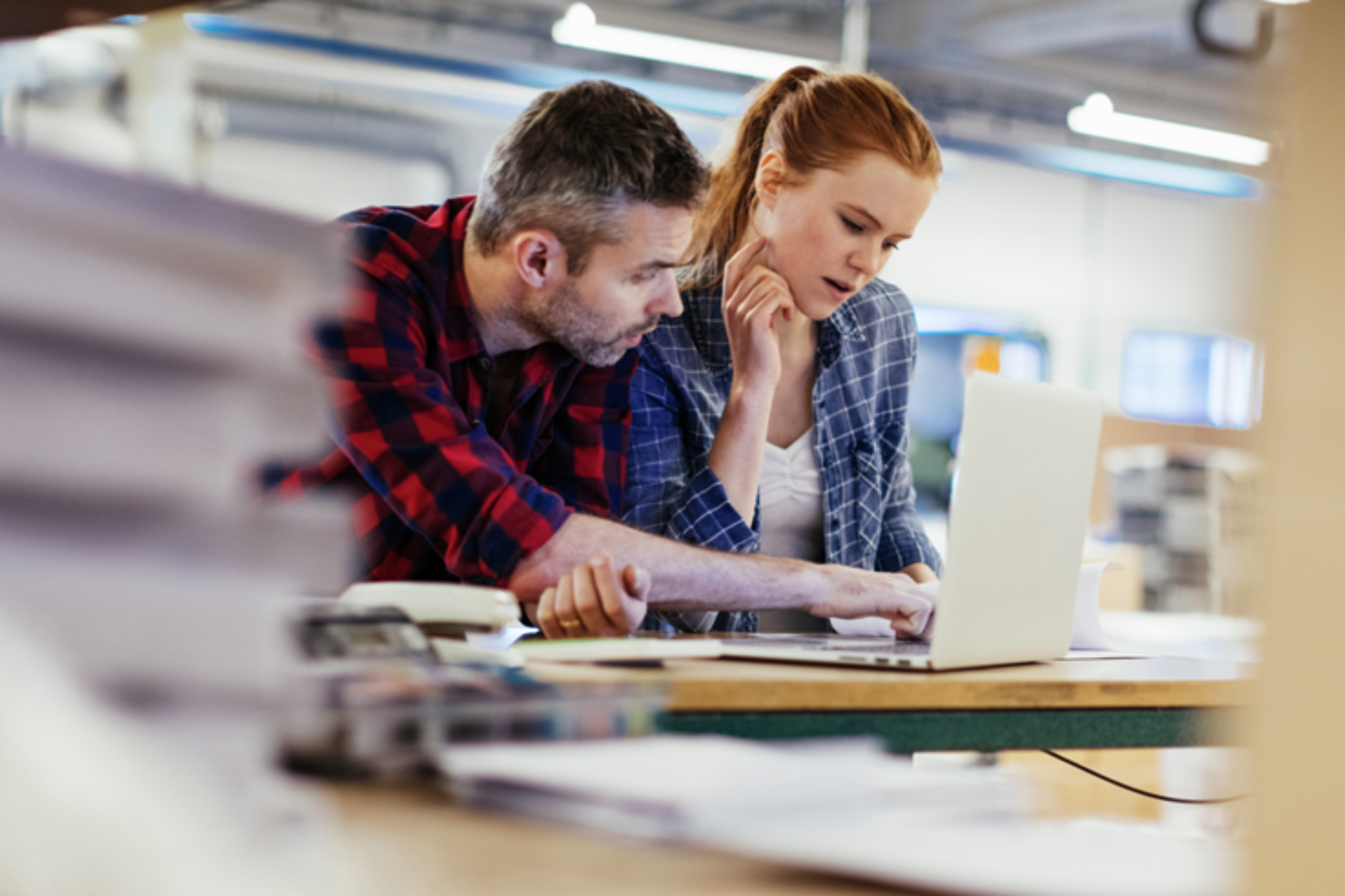 Deux professionnels consultant ensemble un ordinateur sur leur lieu de travail