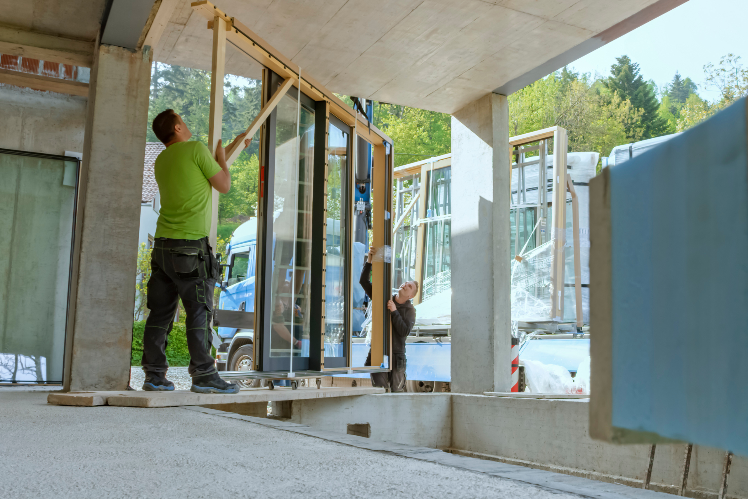 Poseurs installant une menuiserie vitrée sur un bâtiment
